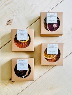 three boxes with orange slices in them sitting on a wooden table next to each other