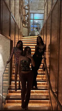 three women are standing on the stairs in an elevator