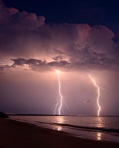 lightning strikes over the ocean on a cloudy night