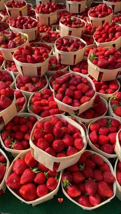 baskets full of strawberries are stacked on top of each other