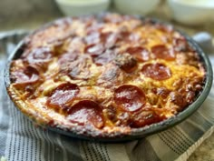 a pepperoni pizza sitting on top of a table