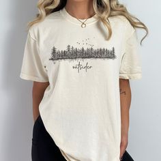 Embrace the wild with our Comfort Colors® "Outsider" t-shirt, featuring a pine tree forest graphic. Perfect for nature lovers and granola girls, this wilderness shirt makes an ideal gift for hikers, campers, and travelers. Prefer this design on a Sweatshirt? Visit this link: https://bohemianbloomdesigns.etsy.com/listing/1666121156 👕 T-Shirt Brand Comfort Colors® 1717 | Unisex Adult Sizing | 100% Ring-Spun US Cotton ⏳🚚 Production & Shipping All items are made-to-order. They will ship within 1-5 Short Sleeve Shirt For Fall Outdoor, Casual Printed Outdoor Tops, Short Sleeve Tops For Fall Outdoor, Short Sleeve Printed Tops For Outdoor, Short Sleeve Tops For Fall Outdoor Events, Printed Short Sleeve Tops For Outdoor, Relaxed Fit Cotton Tops For Adventure, Short Sleeve Shirt For Outdoor Fall Activities, Cotton T-shirt For Outdoor Activities In Fall