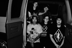 a group of young men standing next to each other in the back of a van