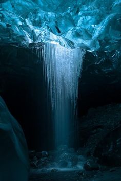 an ice cave with icicles on the ceiling and water running down it's sides