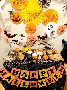 a table topped with lots of halloween decorations and paper fan decorating on top of it