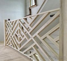 a wooden stair railing in a room with white walls and wood flooring on the side