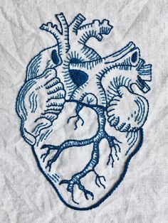 an embroidered heart on a white shirt with blue threadwork in the shape of a human heart