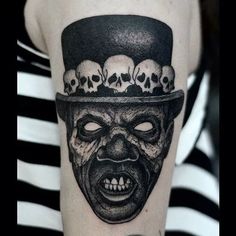 a man's arm with skulls and a top hat on it