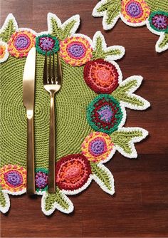 the placemats are decorated with crochet flowers and gold cutlery forks