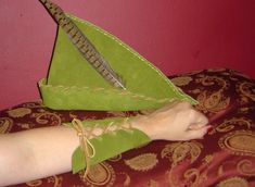 a woman's feet with green shoes and an origami boat