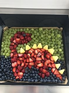 a tray with grapes, strawberries and blueberries arranged in the shape of a kangaroo