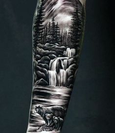 a man's arm with a bear and waterfall tattoo on it