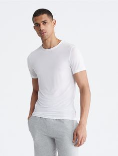 Sleep with ultrasoft comfort. The fitted, breathable design with added stretch is perfect for lounging and rest. Crafted from responsibly sourced modal, this Calvin Klein t-shirt features a crewneck, a fitted body and seaming details.  Material: 87% Modal, 13% Elastane. Sleep Tops, Soft Modern, Modern Lounge, Calvin Klein Men, Stretch Fabric, Calvin Klein, Lounge, Short Sleeves, Sleep