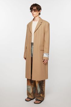 Single-breasted wool coat is cut to a regular fit and knee length. Complete with a concealed front closure and detailed with an Acne Studios Couture label. Crafted from a heavy wool blend. FN-MN-OUTW001039 Beige Wool Coat With Notch Lapel, Beige Notch Lapel Wool Coat, Designer Single Breasted Wool Coat For Work, Designer Single-breasted Wool Coat For Work, Beige Wool Coat For Tailoring, Beige Wool Coat With Hidden Button Closure, Designer Single Breasted Wool Coat With Notch Lapel, Beige Wool Coat With Hidden Buttons, Designer Single-breasted Wool Coat With Notch Lapel