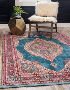 a blue rug with an elephant on it next to a chair and potted plant