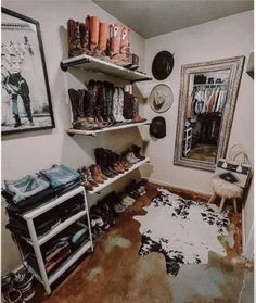 a mud floor in a room with shoes and hats on the shelves next to a mirror