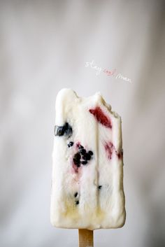 a popsicle with blueberries and cream on it