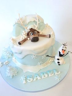 a frosted cake with a dog and snowman on it