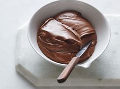 a white bowl filled with chocolate on top of a table