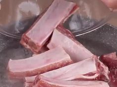 raw meat being cut into pieces in a bowl