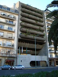 an apartment building with plants growing out of the roof and balconies on top