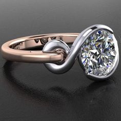 a ring with a diamond in the middle on a black surface and an oval shaped band around it