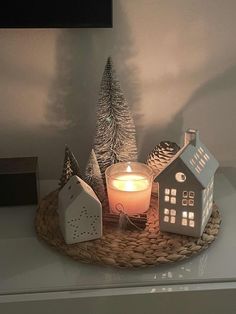 a candle and some houses on a tray