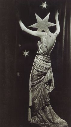 an old photo of a woman with stars on her head and arms in the air