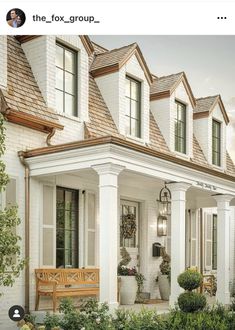 a white house with two porches and some plants in the front yard, on instagram