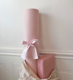 a stack of pink blocks sitting on top of a pile of white paper wrapped in twine