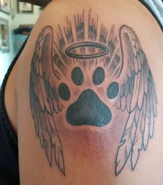 a man with a dog's paw and angel wings tattoo on his back shoulder