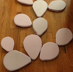 several pieces of white painted rock laid out on a wooden floor