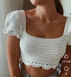 a close up of a person wearing a white top with crochet on it