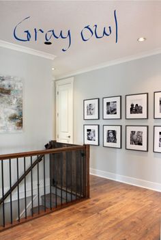 an entry way with framed pictures on the wall and stairs leading up to the second floor