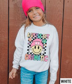 Our retro smiley face graphic sweatshirt features a little bit dramatic happy face design. You'll love the Gildan fabric that ensures a soft and comfortable feel, keeping your child feeling cozy all day long. ✩ Kids Smiley Face Sweatshirt, A Little Dramatic Happy Face Shirt, Cute Youth Retro Smile Crewneck, Girls Trendy Preppy Aesthetic Graphic Tee ✩ 𝗠𝗮𝘁𝗰𝗵𝗶𝗻𝗴 𝗔𝗱𝘂𝗹𝘁 𝗦𝘄𝗲𝗮𝘁𝘀𝗵𝗶𝗿𝘁: https://starrieapparel.etsy.com/listing/1655238149 ✩ 𝗙𝗶𝗻𝗱 𝗠𝗼𝗿𝗲 𝗞𝗶𝗱𝘀 𝗦𝗵𝗶𝗿𝘁𝘀: https://www.etsy.com/shop/StarrieApparel?sort_order=custom&search_query=kids ✩ Our shop uses direct-to-garment printing to make our products. The design ink is sprayed on, then allowed to soak into the fibers of the garment. This process yields fine quality prints and a smooth finish on the garment. 𝗚 Fun Cartoon Print Sweatshirt, Fun Cotton Sweatshirt With Character Print, Cute Long Sleeve Smiley Face Top, Playful Cotton Sweatshirt With Funny Print, Fun Sweatshirt With Funny Print Relaxed Fit, Relaxed Fit Fun Sweatshirt With Funny Print, Relaxed Fit Funny Print Sweatshirt, Happy Face Shirt, Smiley Face Sweatshirt