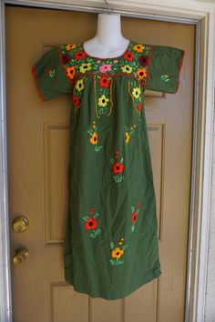 An ethnic, summer festive dress that is embellished with embroidery  throughout. Calf length with short sleeves.  Small.Measurements taken across front laid flatBust.................................18"Shoulder to hem.............40"Waist...............................23" Multicolor Embroidered Dress For Summer Festivals, Summer Festive Dress With Embroidered Border, Green Bohemian Embroidered Spring Dress, Green Bohemian Embroidered Dress For Spring, Traditional Green Embroidered Dress For Festivals, Green Embroidered Short Sleeve Dress For Spring, Spring Green Embroidered Dress With Short Sleeves, Green Embroidered Dress With Short Sleeves For Spring, Summer Festival Embroidered Short Sleeve Dress