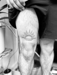 a man's leg with a sun tattoo on the lower half of his leg