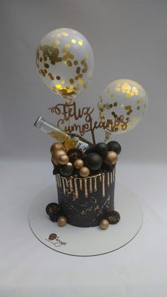 a birthday cake with balloons and confetti on top