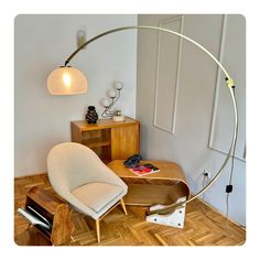 a living room with a chair, lamp and other items on the wooden flooring