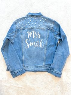 a denim jacket with the words mrs smith on it and studded details in white