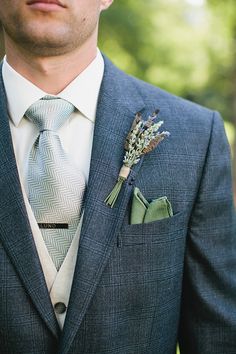 a man wearing a suit and tie with a boutonniere on his lapel