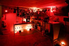 a dimly lit kitchen with red lighting in the ceiling and appliances on the countertop