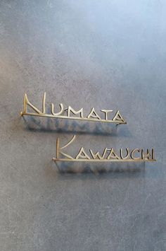 two metal nameplates with the words namita and kawachi on them