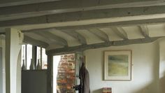 an open door leading into a room with exposed beams and brickwork on the walls