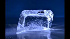 an ice block with water on it sitting in the middle of a dark blue background