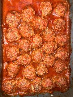 meatballs covered in marinara sauce on a baking sheet