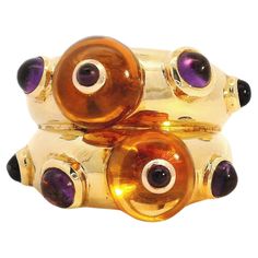 This magnificent citrine and amethyst ring is a one-of-a-kind piece of artisanal jewelry that would make a treasured addition to any fine accessories collection. Crafted from 18-karat yellow gold, it features two expertly cut citrine beads. Nestled between each bead is a subtly placed Cabochon Amethyst accent that enhances the luminous golden glow of the citrines. The mix of natural gemstones creates a beautifully balanced design full of depth, light, and surprise around each turn. Wearing this Luxury Amethyst Cabochon Ring, Unique Yellow Gold Amethyst Ring, Luxury Citrine Cabochon Jewelry, Gold Luxury Amethyst Multi-stone Ring, Luxury Gold Amethyst Multi-stone Ring, Yellow Gold Amethyst Cabochon Gemstones, Luxury Gold Multi-stone Amethyst Ring, Unique Multi-stone Gold Amethyst Ring, Unique Gold Multi-stone Amethyst Ring