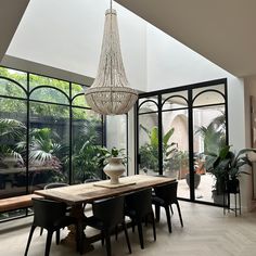 a dining room table with chairs and a chandelier hanging from it's ceiling