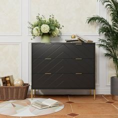 a black dresser sitting next to a potted plant