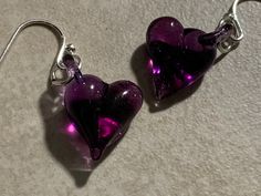 Love Heart Earrings Tiny little purple blown glass earring jewelry! Whether you are a minimalist or just love small Earrings your going to Love these deep purple glass earrings! They are very strong but light handmade jewelry! You can request them with gold or silver wires, real or plated at the style button next to the photo above. The plated ones are hypo-allergenic. I make each item after it is ordered. With my 50 some years of experience I can make it very close to the item shown in the pict Handmade Purple Earrings For Valentine's Day, Handmade Purple Heart Earrings For Gift, Handmade Purple Heart Earrings Gift, Purple Earrings For Valentine's Day Gift, Purple Heart Beads Earrings For Gift, Purple Heart Charm Earrings For Valentine's Day, Handmade Purple Heart Earrings For Valentine's Day, Purple Heart Earrings, Love Jewelry